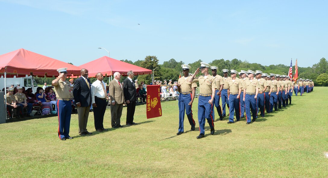 Sgt. Maj. Conrad Potts, outgoing sergeant major, Marine Corps Logistics Base Albany (left), along with a few guests he invited to accompany him, salutes as a platoon of Marines conducts a Pass and Review during a retirement ceremony at Schmid Field, May 23.