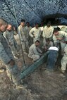 Gunnery Sgt. David Marinelarna, the field artillery chief of 2nd Battalion 11th Marine Regiment, demonstrates the proper way to secure  gear on the M777A2 light weight howitzer before a helicopter lift during Exercise Desert Scimitar at Marine Corps Air Ground Combat Center Twentynine Palms, Calif., May 8 2014. Desert Scimitar is a two-week, combined-element exercise to prepare Marines for deployments.  A helicopter is able to transport the howitzer quickly to locations that would otherwise be inaccessible. (U.S. Marine Corps photo by Lance Cpl. Ashton Buckingham)
