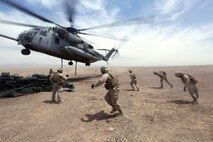 Marines with Combat Logistics Battalion 1 run to a M777A2 lightweight howitzer while a Ch-53 super stallion helicopter hovers above during Exercise Desert Scimitar at Marine Corps Air Ground Combat Center Twentynine Palms, Calif., May 8 2014. Desert Scimitar is a two-week, combined-element exercise to prepare Marines for deployments.  The Ch-53 is able to transport a howitzer quickly to locations that would otherwise be inaccessible. (U.S. Marine Corps photo by Lance Cpl. Ashton Buckingham)