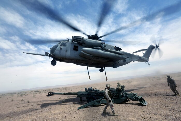 A Ch-53 super stallion helicopter sets a M777A2 lightweight howitzer down during Exercise Desert Scimitar at Marine Corps Air Ground Combat Center Twentynine Palms, Calif., May 8 2014. Desert Scimitar is a two-week, combined-element exercise to prepare Marines for deployments.  The Ch-53 is able to transport a howitzer quickly to locations that would otherwise be inaccessible. (U.S. Marine Corps photo by Lance Cpl. Ashton Buckingham)