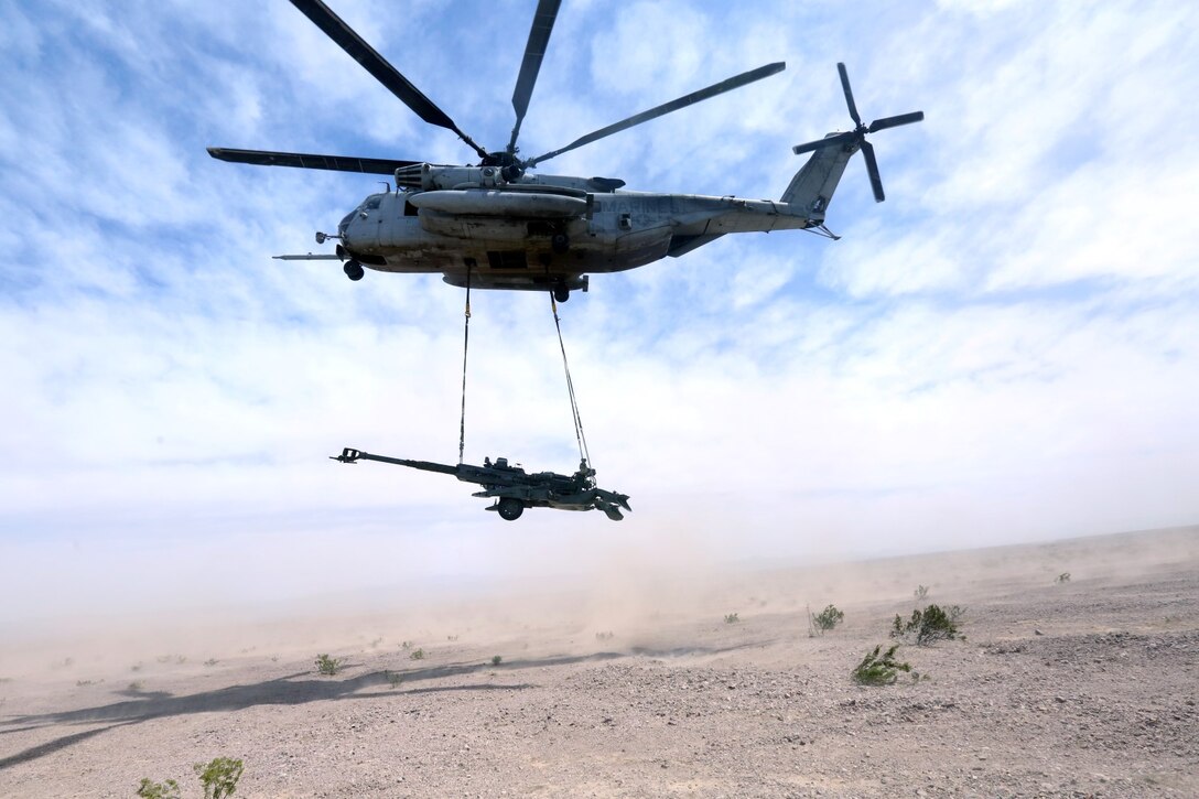 A Ch-53 super stallion helicopter lifts a M777A2 lightweight howitzer during Exercise Desert Scimitar at Marine Corps Air Ground Combat Center Twentynine Palms, Calif., May 8 2014. Desert Scimitar is a two-week, combined-element exercise to prepare Marines for deployments.  The Ch-53 is able to transport a howitzer quickly to locations that would otherwise be inaccessible. (U.S. Marine Corps photo by Lance Cpl. Ashton Buckingham)