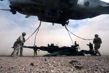 Marines with Combat Logistics 1 hook  the M777A2 lightweight howitzer up to a Ch-53 super stallion helicopter during Exercise Desert Scimitar at Marine Corps Air Ground Combat Center Twentynine Palms, Calif., May 8 2014. Desert Scimitar is a two-week, combined-element exercise to prepare Marines for deployments.  The Ch-53 is able to transport a howitzer quickly to locations that would otherwise be inaccessible. (U.S. Marine Corps photo by Lance Cpl. Ashton Buckingham)