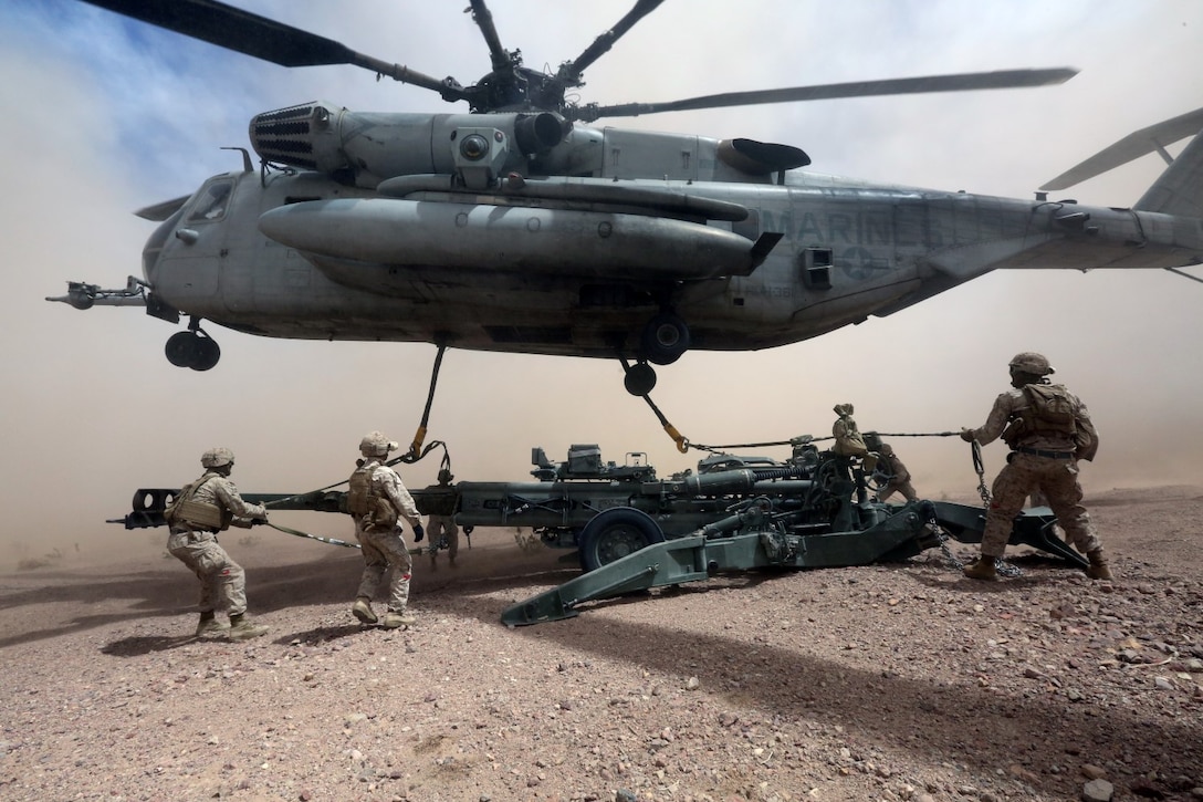 Marines with Combat Logistics One hook the M777A2 lightweight howitzer up to a Ch-53 super stallion helicopter during Exercise Desert Scimitar at Marine Corps Air Ground Combat Center Twentynine Palms, Calif., May 8 2014. Desert Scimitar is a two-week, combined-element exercise to prepare Marines for deployments.  The Ch-53 is able to transport a howitzer quickly to locations that would otherwise be inaccessible. (U.S. Marine Corps photo by Lance Cpl. Ashton Buckingham)