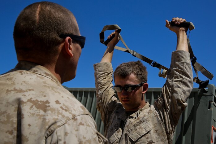 Petty Officer 2nd Class Daniel Wagner, left, a hospital corpsman with Headquarters Battalion, 1st Marine Division, monitors Lance Cpl. Aaron Brown, a motor transport operator with the battalion, during a physical therapy session at Marine Corps Air Ground Combat Center Twentynine Palms, Calif., May 14, 2014. Wagner routinely improvises medical treatment while in the field. He understands the work tempo of the Marines requires the battalion aid station to be creative when continuing treatment for their patients.