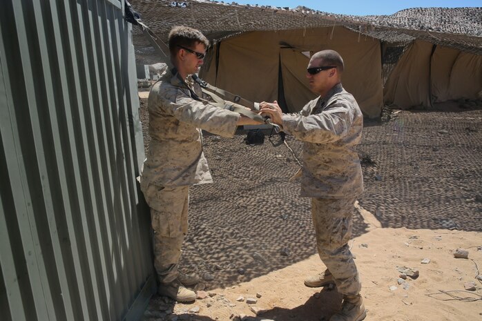 Petty Officer 2nd Class Daniel Wagner, left, a hospital corpsman with Headquarters Battalion, 1st Marine Division, monitors Lance Cpl. Aaron Brown, a motor transport operator with the battalion, during a physical therapy session at Marine Corps Air Ground Combat Center Twentynine Palms, Calif., May 14, 2014. Wagner routinely improvises medical treatment while in the field. He understands the work tempo of the Marines requires the battalion aid station to be creative when continuing treatment for their patients.