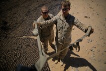 Petty Officer 2nd Class Daniel Wagner, left, a hospital corpsman with Headquarters Battalion, 1st Marine Division, monitors Lance Cpl. Aaron Brown, a motor transport operator with the battalion, during a physical therapy session at Marine Corps Air Ground Combat Center Twentynine Palms, Calif., May 14, 2014. Wagner routinely improvises medical treatment while in the field. He understands the work tempo of the Marines requires the battalion aid station to be creative when continuing treatment for their patients.