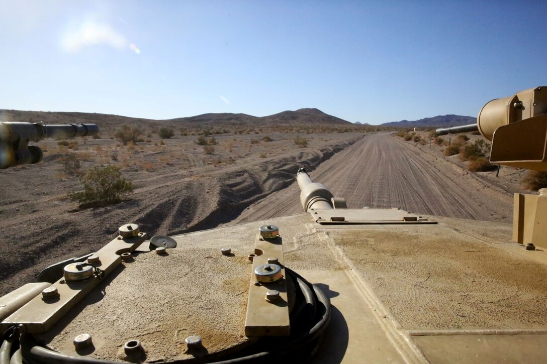 Marines with Alpha Company, 1st Tank Battalion, scan the horizon with an M1A1 abrams main battle tank during Exercise Desert Scimitar 2014 aboard Marine Corps Air Ground Combat Center Twentynine Palms, Calif., May 11, 2014. A tank's success on the battlefield is defined by the teamwork of its four crewmen, who each play a vital role. The mission cannot be completed without every member. Each crewman has a specific yet equally important job required to operate the vehicle. (U.S. Marine Corps photo by Cpl. Christopher J. Moore/Released)