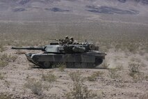Marines with Alpha Company, 1st Tank Battalion, advance on a mock enemy position in an M1A1 Abrams during Exercise Desert Scimitar 2014 aboard Marine Corps Air Ground Combat Center Twentynine Palms, Calif., May 11, 2014. A tank's success on the battlefield is defined by the teamwork of its four crewmen, who each play a vital role. The mission cannot be completed without every member. Each crewman has a specific yet equally important job required to operate the vehicle. (U.S. Marine Corps photo by Cpl. Christopher J. Moore/Released)