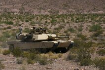 Marines with Alpha Company, 1st Tank Battalion, advance in formation on a mock enemy position in an M1A1 Abrams main battle tank during Exercise Desert Scimitar aboard Marine Corps Air Ground Combat Center Twentynine Palms, Calif., May 11, 2014. The training gave the Marines the opportunity to refine and rehearse essential combat skills needed in a battlefield environment. Desert Scimitar is an annual exercise that includes elements from the I Marine Expeditionary Force. The exercise focused on conventional operations and provided realistic training that prepared Marines for overseas operations. (U.S. Marine Corps photo by Cpl. Christopher J. Moore/Released)