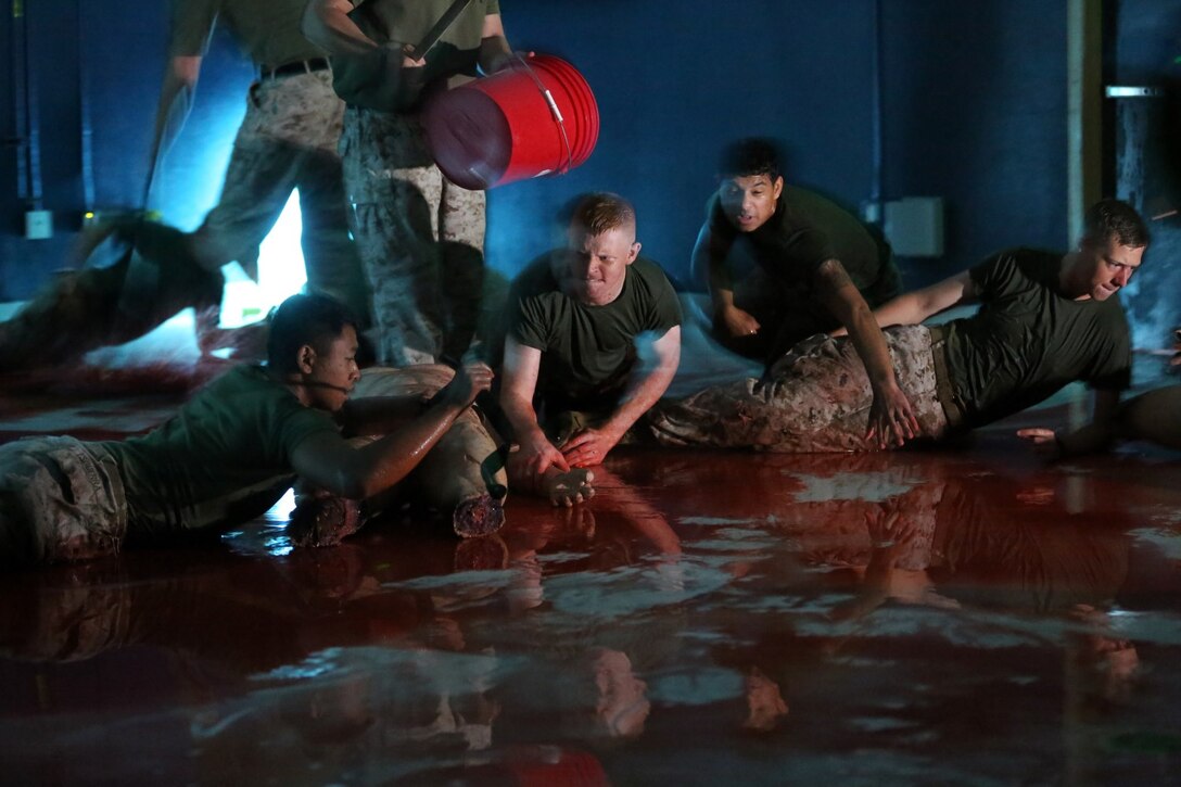 Corpsmen rush into a darkened room during a hemorrhage control practical exercise to secure tourniquets to double-amputee practice dummies, May 23, 2014.  Marine Corps and Navy instructors from FMTB taught students the basics of hemorrhage control aboard Camp Pendleton, California.