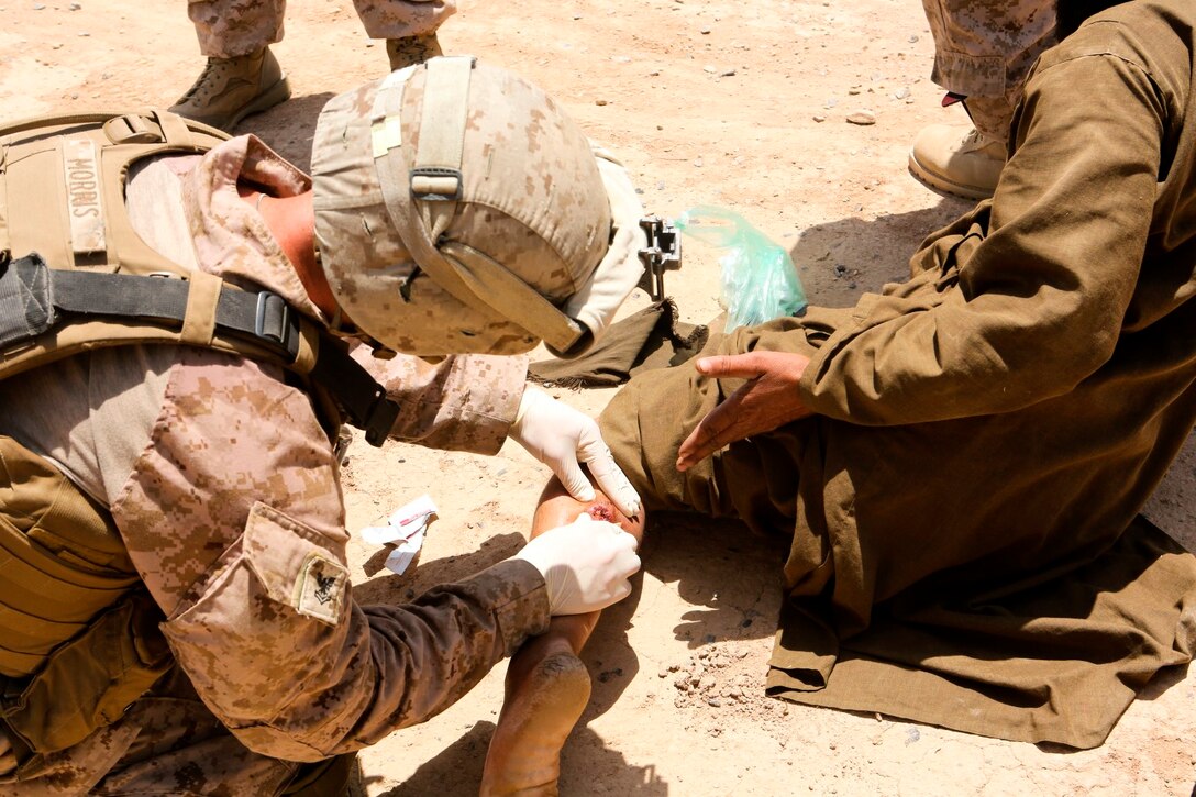 Petty Officer 2nd Class Seth Morris, a native of Harrington, Washington, provides medical treatment to a local Afghan elder during a security patrol near the town of Boldak in Helmand province, Afghanistan, May 21, 2014. Morris, a corpsman with 1st Battalion, 2nd Marine Regiment, and the Marines and sailors of the unit conduct daily patrols in order to maintain trust and communication with the local Afghan population. (U.S. Marine Corps photo by Cpl. Michael Dye/Released)