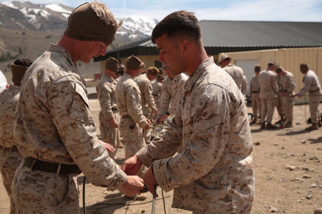 Sgt. Gregory T. Bell, mountain warfare instructor, Marine Corps Mountain Warfare Training Center, instructs Marines on the proper technique to tying a specific knot during the knot-tying portion of the Instructor Qualification Course at the lower base camp of MCMWTC, May 1, 2014.