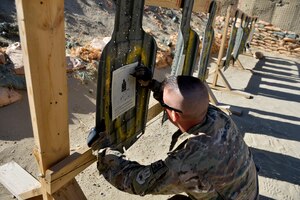Tech Sgt. Benjamin Huss, 455th Base Defense Squadron combat arms training instructor, reviews a firing target May 24, 2014 at Bagram Airfield, Afghanistan. As a CATM instructor, Huss ensures Air Force weapons are functional and assists the Army in range operations. Huss is deployed from Langley Air Force Base, Va. and a native of Fremont, Ohio. (U.S. Air Force photo by Staff Sgt. Evelyn Chavez/Released)