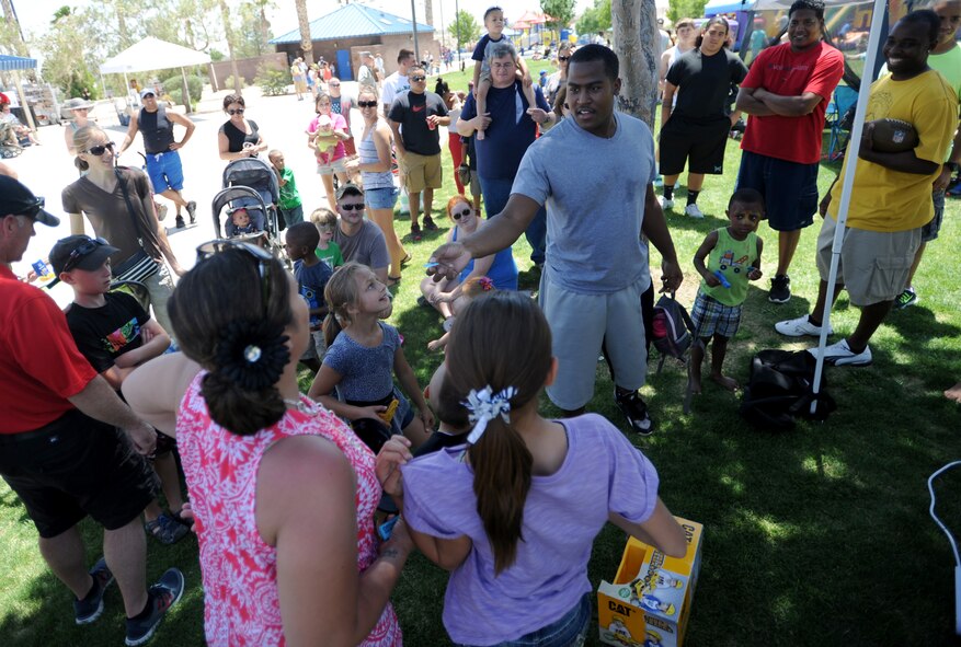 Staff Sgt. Nicholas presents his raffle ticket after winning a toy for his daughter, Keimora, during the 2014 Creech Summer Bash event at Lone Mountain Park May 19, 2014. The Summer Bash is an annual Creech Resiliency event promoting family, fun, and camaraderie (Last names have been withheld for security reasons). (U.S. Air Force photo by Senior Master Sgt. C.R.)