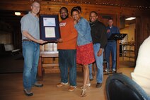 Deachole Greene hugs her husband Stacy Green after Col. Paul Bauman, 319th Air Base Wing commander and Chaplain (Maj.) Steven Dabbs, 319th ABW head chaplain, present him with a certificate and letter from the Office of the President of the United States recognizing him as a recipient of a Lifetime Presidential Volunteer Service Award during a volunteer appreciation picnic held May 15, 2014, at Turtle River State Park, N.D. The Lifetime Award is the highest recognition in the PVSA program. It is awarded to a person who has donated 4,000 volunteer hours or more over a lifetime. Mr. Green generously donated a total of 5,144 hours. Mrs. Green also recieved a Lifetime PVSA for her 4,388 hours. (U.S. Air Force photo/Staff Sgt Luis Loza Gutierrez)