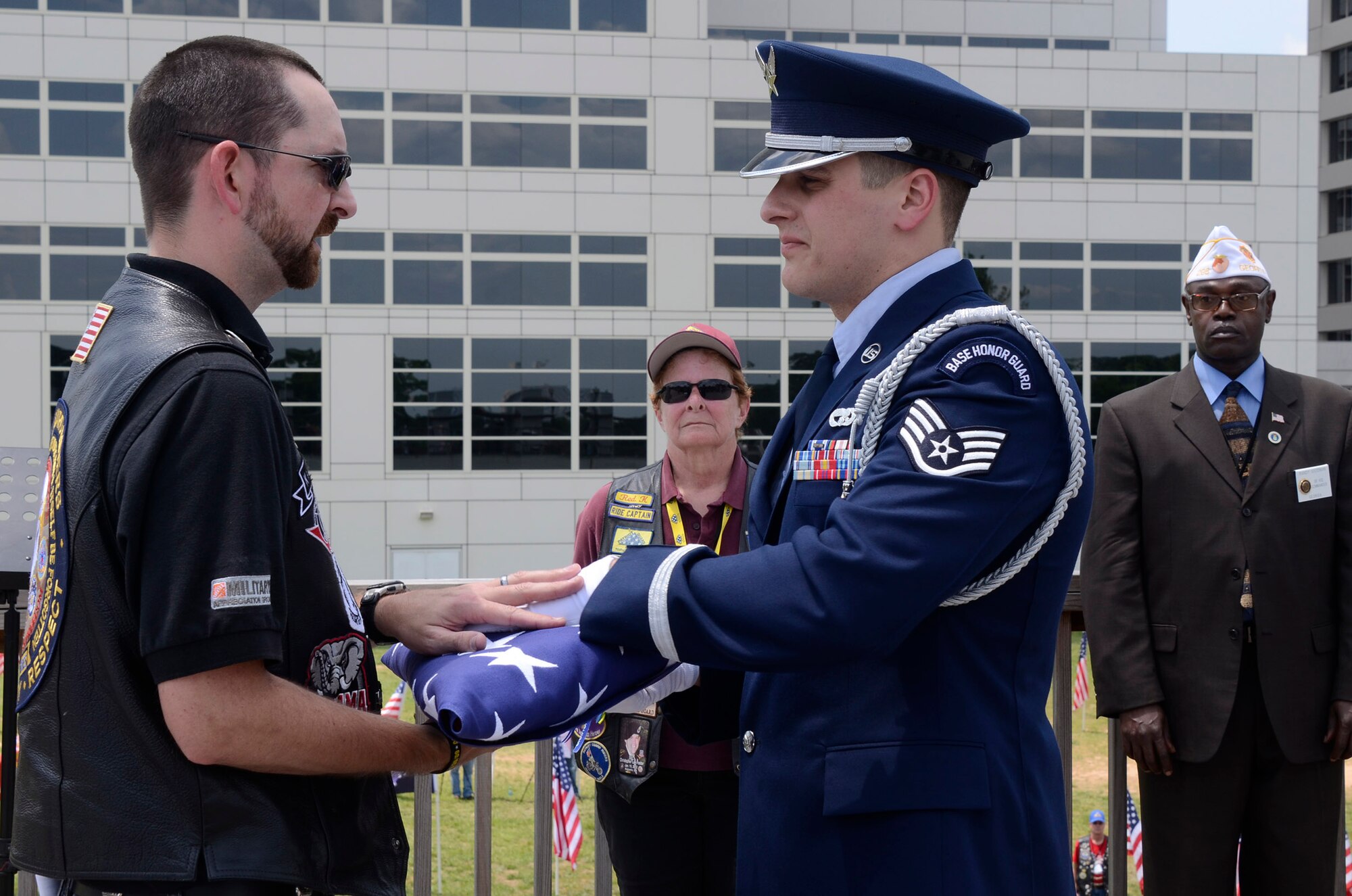 Staff Sgt. Joshua Koon, from the 94th Airlift Wing Honor Guard, Dobbins Air Reserve Base, Ga., presents flag to a member of the Patriot Guard Riders Association while Nancy “Red K” Hitching, PGR, and Randy Goodman, American Legion of Georgia, senior vice commander looks on, during a flag folding ceremony at a Military Appreciation Group luncheon sponsored by The Home Depot Corporate Headquarters, Atlanta, Ga. May 23, 2014. The program included Flag-Line demonstration by Patriot Guard Riders Association, Missing Man Table, and Fallen Heroes Bell Ceremonies. (U.S. Air Force photo/Don Peek)