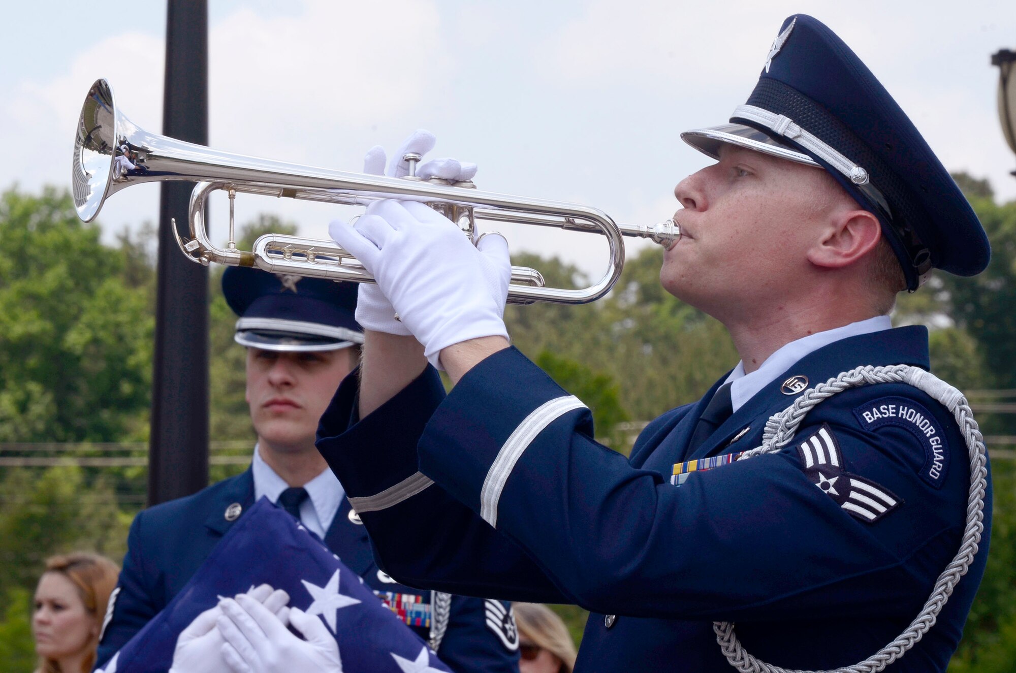 Senior Airman James Brannon, from the 94th Airlift Wing Honor Guard, Dobbins Air Reserve Base, Ga., sounds taps as Staff Sgt. Joshua Koon prepares to pass on the flag during a flag folding ceremony at a Military Appreciation Group luncheon sponsored by The Home Depot Corporate Headquarters, Atlanta, Ga. May 23, 2014. The program included Flag-Line demonstration by Patriot Guard Riders Association, Missing Man Table, and Fallen Heroes Bell Ceremonies. (U.S. Air Force photo/Don Peek)