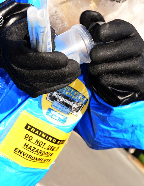 U.S. Air Force Senior Airman Christopher Cameron, 23d Aerospace Medicine Squadron bioenvironmental engineering technician, opens an empty container during training, at Moody Air Force Base, Ga., May 29, 2014. Some of the duties of bioenvironmental Airmen include gas mask fit testing, water testing, measuring thermal conditions during the summer months and responding to chemical, biological, radiological, nuclear and physical threats. (U.S. Air Force photo by Senior Airman Tiffany M. Grigg/Released) 