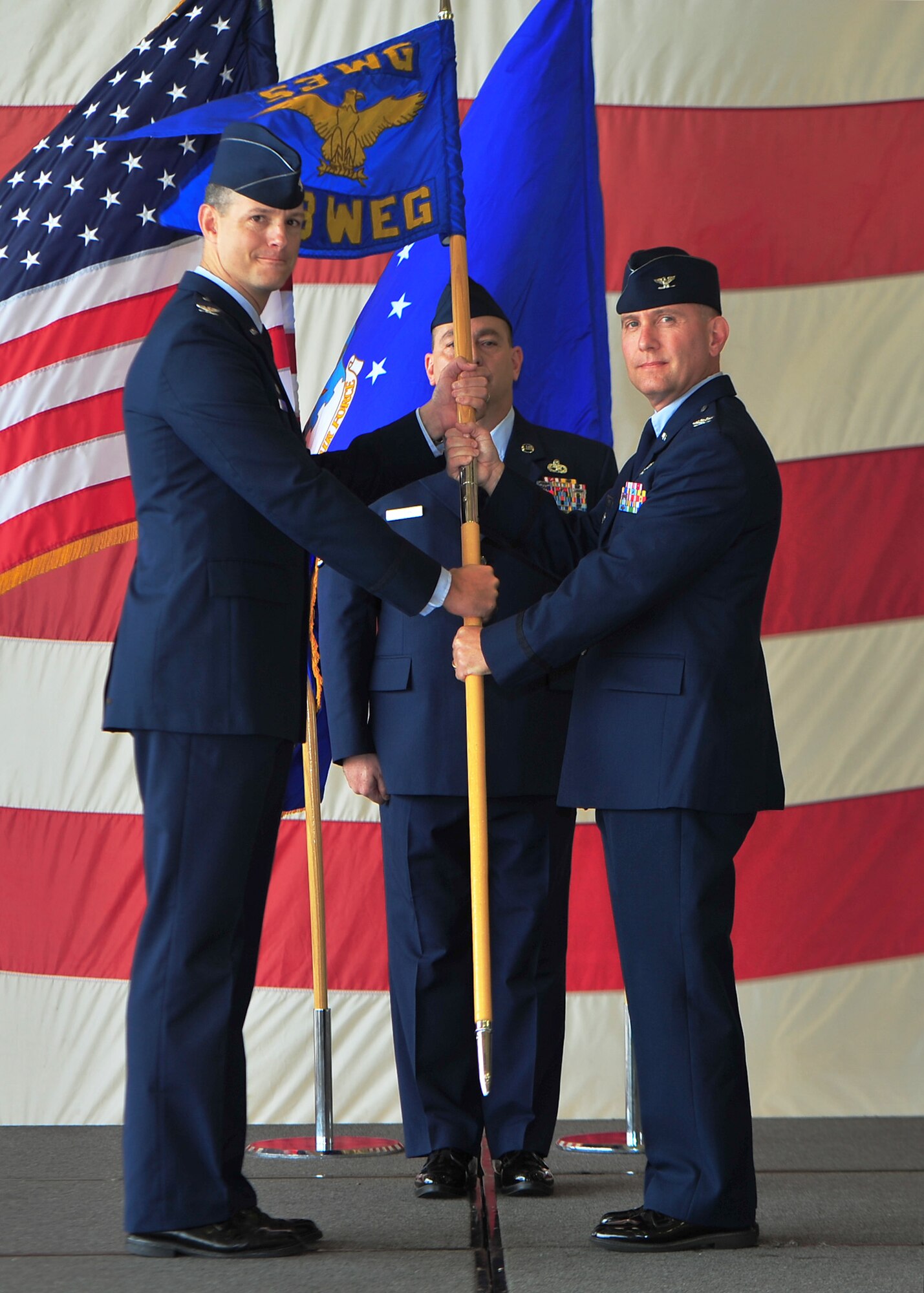 Col. Alexus Grynkewich, the 53rd Wing commander, Eglin Air Force Base, Fla., passes the 53rd Weapons Evaluation Group guidon to Col. Scott L. Ward, 53rd WEG commander, during a change of command ceremony May 29. Ward replaces Col. James R. Vogel who will retire May 30. (U.S. Air Force photo by Airman 1st Class Dustin Mullen)