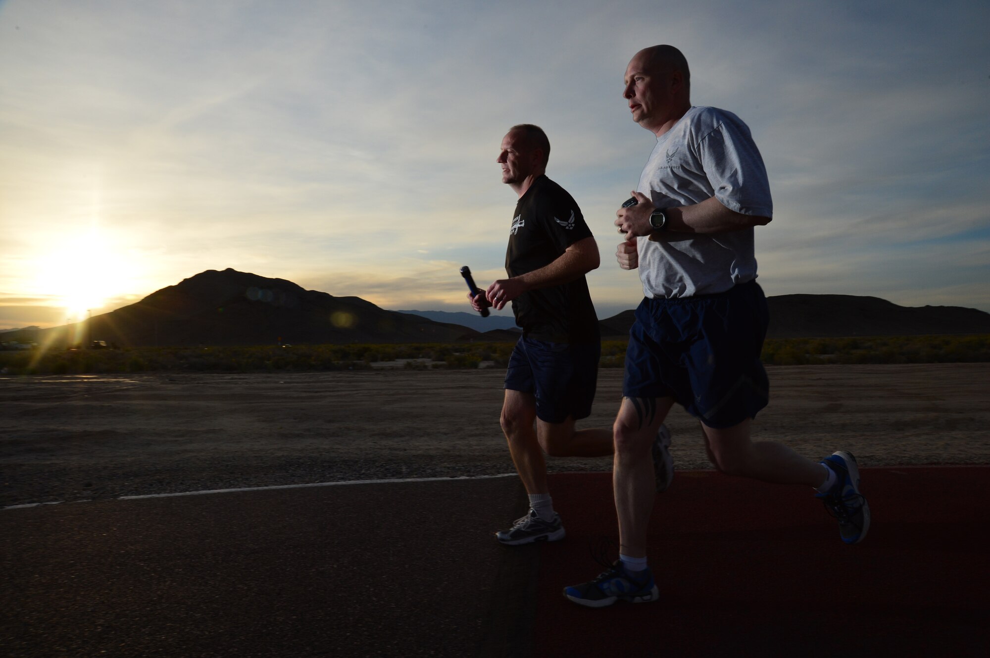 Chief Master Sgt. Paul Pohnert, left, 799th Air Base Squadron superintendent, and Master Sgt. Robert Livingston, 799th ABS first sergeant, participate in a 24-hour vigil run at Creech Air Force Base, Nev., during National Police Week May 16, 2014. Each runner carried a baton containing the names of 286 U.S. law enforcement officers who lost their lives during the past year. (U.S. Air Force photo by Tech. Sgt. S.E./Released)