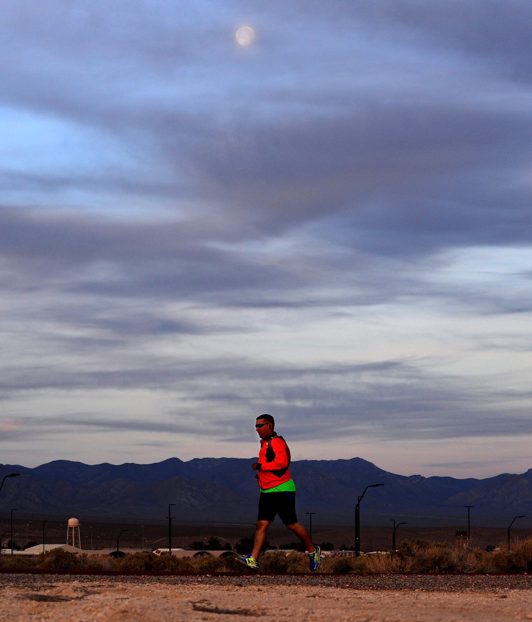 Master Sgt. Ruben Martinez, 799th Air Base Squadron non-commissioned officer in charge of operations, runs under the moon during his 5:30 a.m. portion of a National Police Week 24-hour vigil run at Creech Air Force Base, Nev., May 16, 2014. Nearly 77 Airmen ran 30-minute shifts to honor the service and sacrifice of all fallen U.S. law enforcement personnel during the event. (U.S. Air Force photo by Tech. Sgt. S.E./Released)