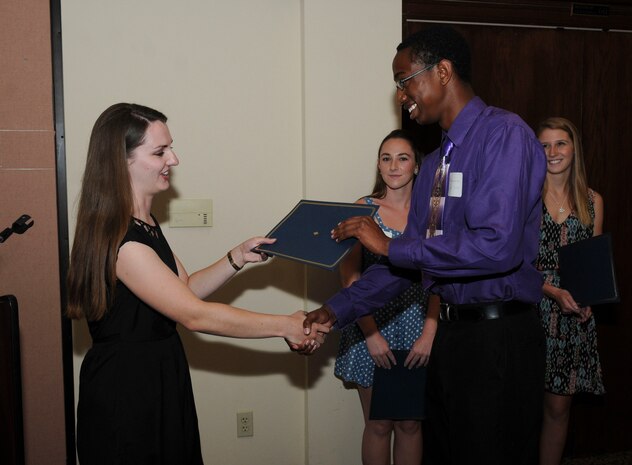 Donovan Young receives a scholarship from Ciara Anderson, Beale Officers’ Spouses’ Club member, during the BOSC annual banquet at the Recce Point Club on Beale Air Force Base, Calif., May 27, 2014. Young was one of four recipients to receive a scholarship. (U.S. Air Force photo by Airman 1st Class Michael Hunsaker/Released)