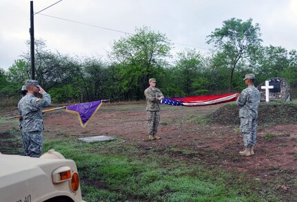 U.S. Navy Master at Arms 3rd Class Tyler Drinski, military working dog handler, and U.S. Army Spc. Hector Giomar Orozco, JSF patrolman and honor guard instructor, conduct a flag folding ceremony. Members of Joint Task Force-Bravo’s Joint Security Forces came together and commemorated U.S. Army Staff Sgt. Randall Harris, a servicemember who died in the line of duty 13 June 1987, with a ruck march followed by a ceremony at Soto Cano Air Base, Honduras May 21, 2014. (Photo by Ana Fonseca)