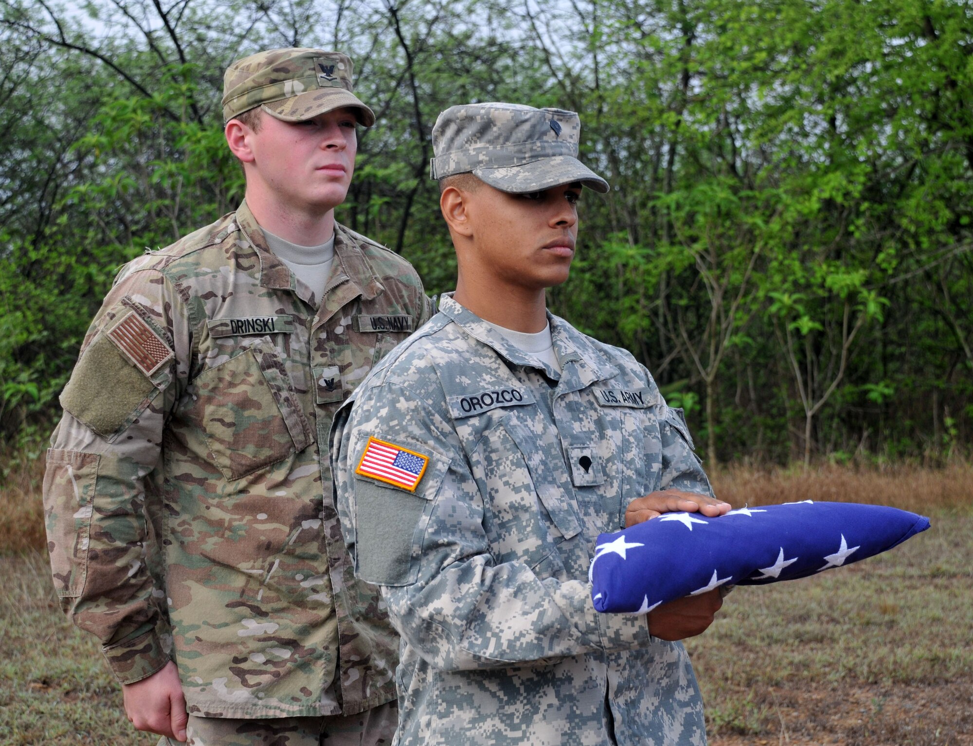 U.S. Navy Master at Arms 3rd Class Tyler Drinski, military working dog handler, and U.S. Army Spc. Hector Giomar Orozco, JSF patrolman and honor guard instructor, conduct a flag folding ceremony. Members of Joint Task Force-Bravo’s Joint Security Forces came together and commemorated U.S. Army Staff Sgt. Randall Harris, a servicemember who died in the line of duty 13 June 1987, with a ruck march followed by a ceremony at Soto Cano Air Base, Honduras May 21, 2014. (Photo by Ana Fonseca)