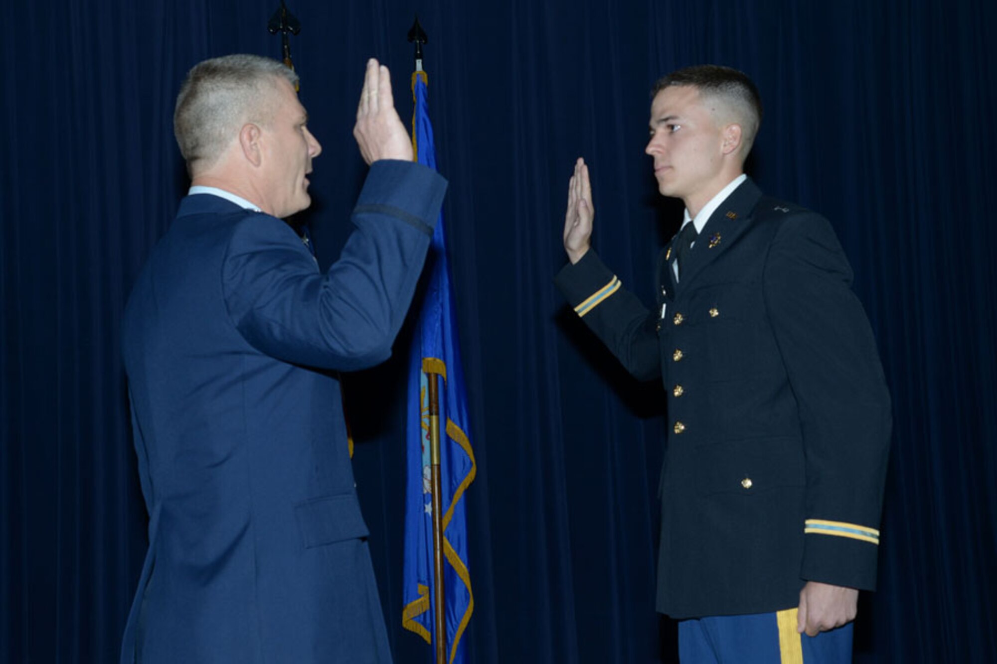Col. Kyle 'Cowboy' Ingham administers the oath of office to 2nd
Lt. Austin Ingham during ceremonies celebrating the colonel's retirement and
his son's commissioning on May 20 at Joint Base-Randolph, Texas. (Air Force photo by Joel Martinez)
