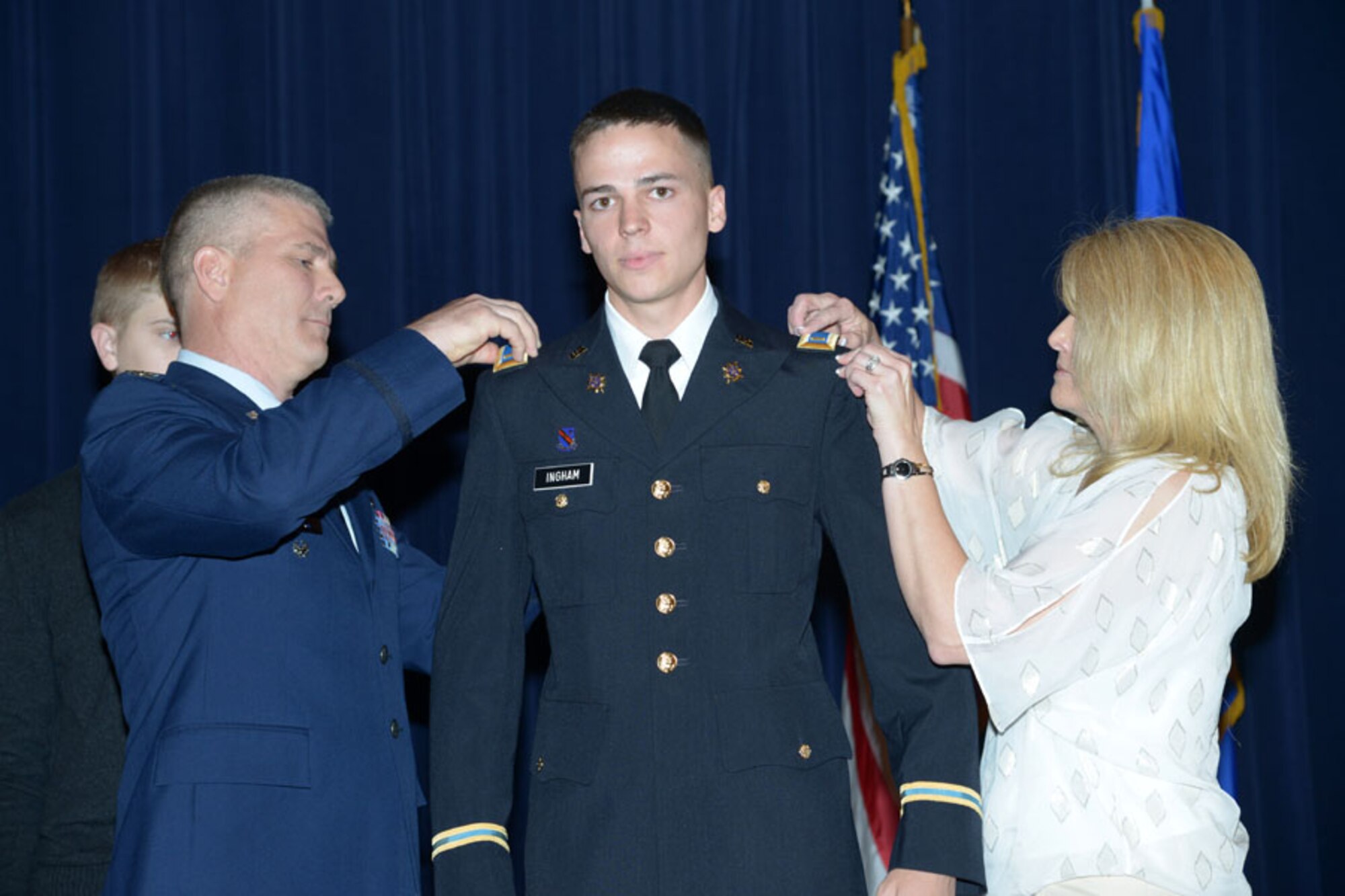 Col. Kyle 'Cowboy' Ingham and his wife Kira pin second lieutenant bars on their son Austin on May 20 at Joint Base-Randolph, Texas, as their son Houston looks on. (Air Force photo by Joel Martinez) 
