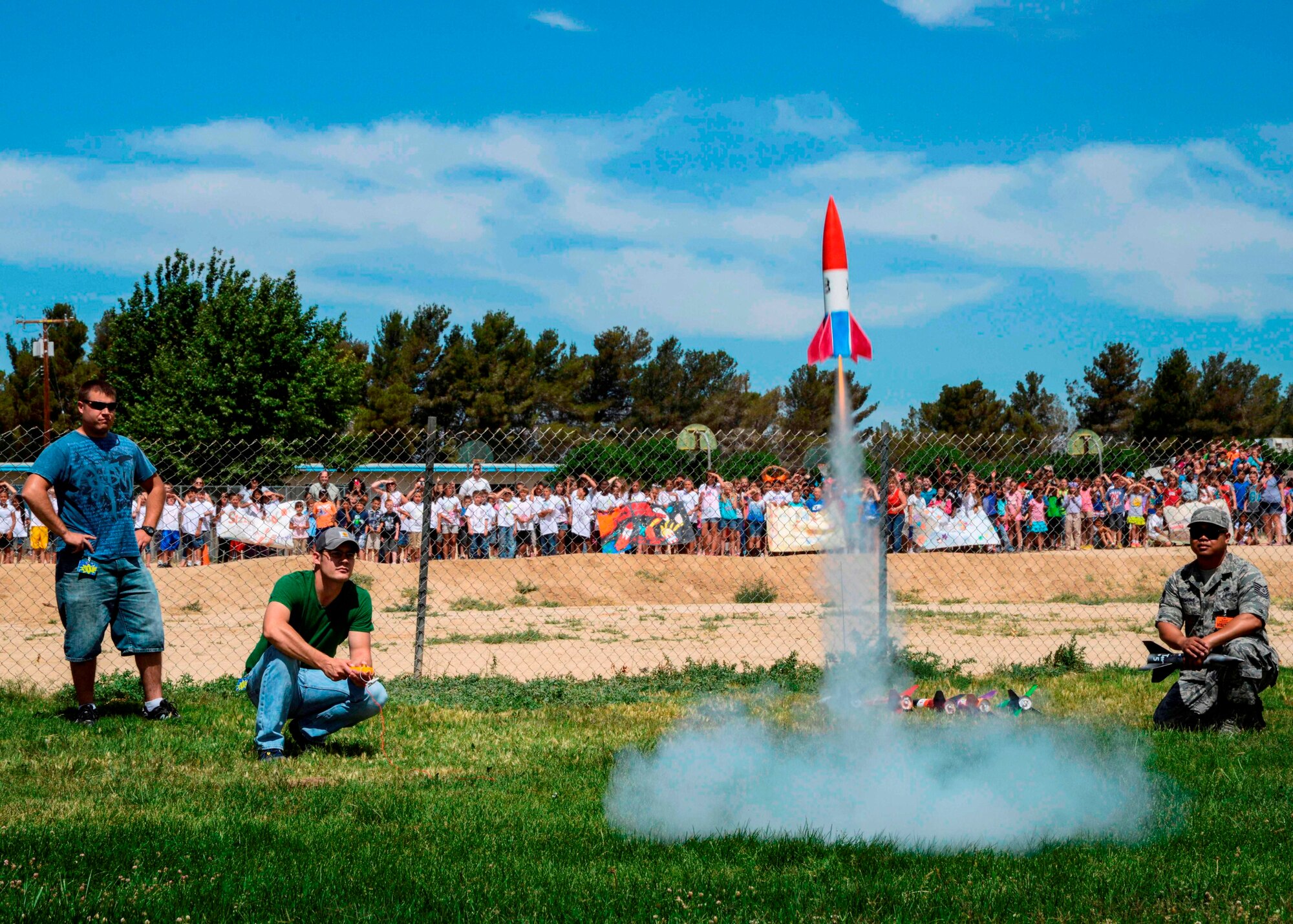 The volunteer launch crew fires up a rocket as the students reach the end of their countdown at the second annual Branch Elementary Rocket Challenge May 28. (U.S. Air Force photo by Rebecca Amber)