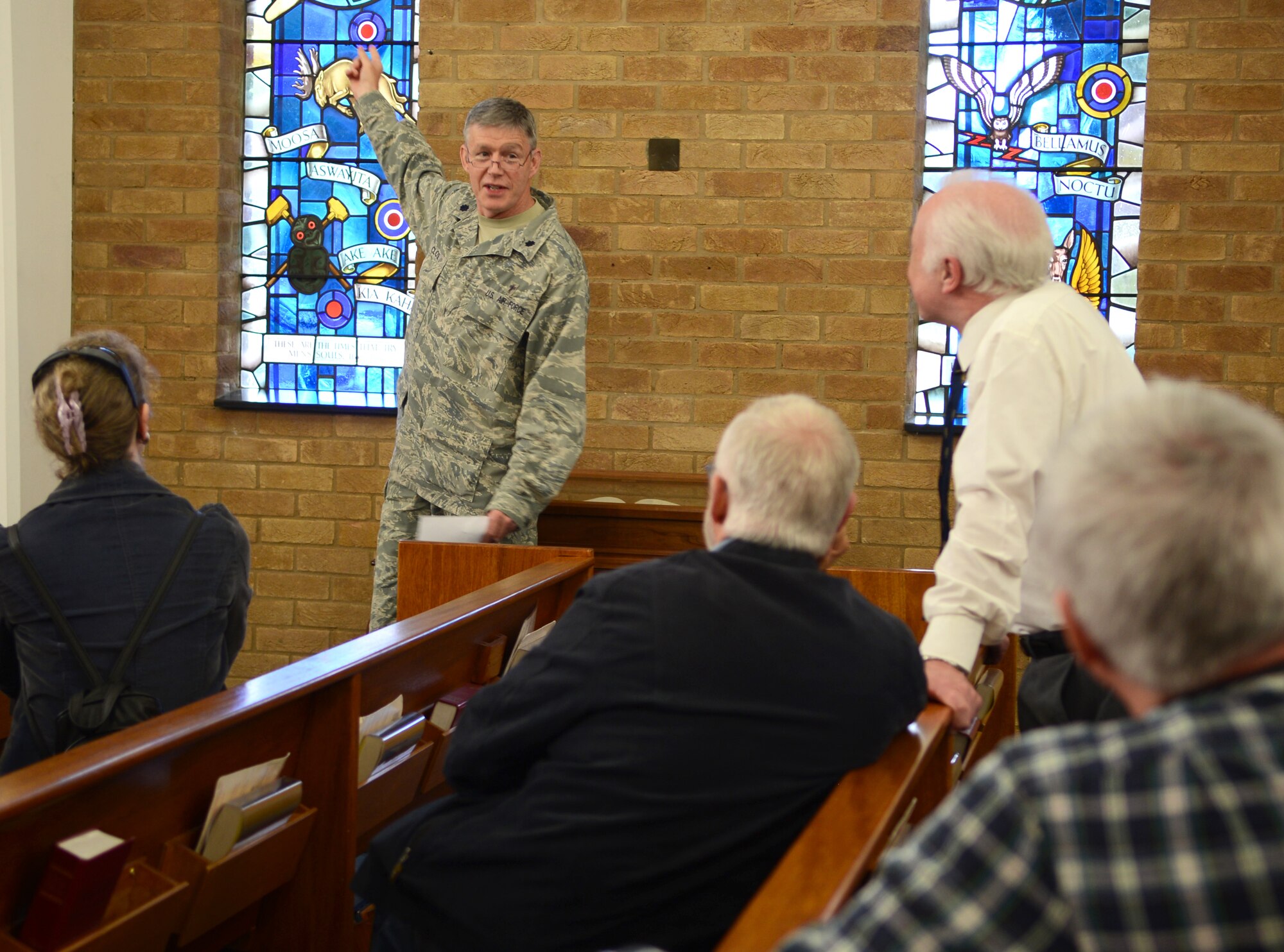 U.S. Air Force Chaplain (Lt. Col.) Henry Close, 100th Air Refueling Wing chaplain, explains the meanings behind the stained glass windows of the base chapel to members of the Mildenhall Register May 16, 2014, during a base tour on RAF Mildenhall, England. The Mildenhall Register holds reunions to perpetuate the memory of those who died in World War II. (U.S. Air Force photo by Airman 1st Class Dillon Johnston/Released)