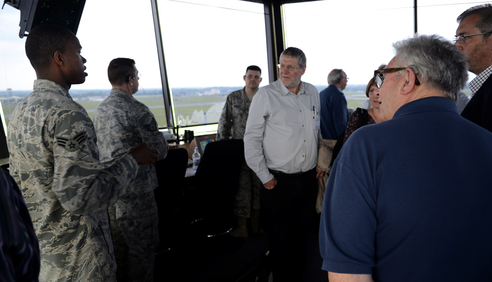U.S. Air Force Senior Airman Weymour Johnson, left, 100th Operations Support Squadron air traffic controller from New York, speaks about the responsibilities of his job to members of the Mildenhall Register May 16, 2014, during a base tour on RAF Mildenhall, England. The Mildenhall Register holds reunions to perpetuate the memory of those who died in World War II. (U.S. Air Force photo by Airman 1st Class Dillon Johnston/Released)