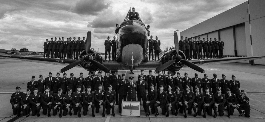 Members of the 37th Airlift Squadron gather for a group photo in front of a Douglas C-47 Skytrain, designated Whiskey 7, on Ramstein Air Base, Germany, May 29, 2014. The 37th AS recreated the historical photo to mimic a photo taken 70-years ago of the exact same aircraft with members of the 37th Troop Carrier Squadron. (U.S. Air Force illustration/Airman 1st Class Jordan Castelan)
