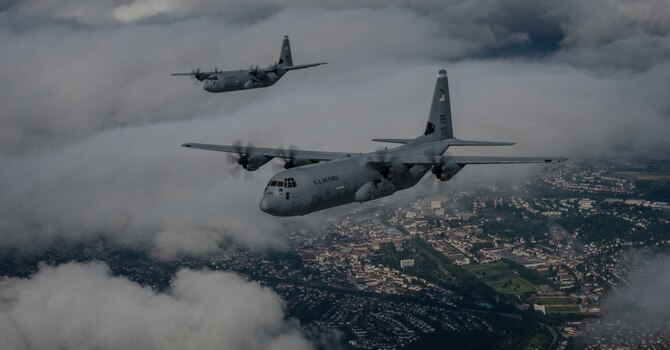 Two 37th Airlift Squadron C-130J Super Hercules aircraft practice flying in formation in preparation for events commemorating the 70th anniversary of D-Day in Normandy, over Germany, May 27, 2014. A Douglas C-47 Skytrain, known as Whiskey 7 led the legacy squadron that would become the 37th AS, recently returned to mainland Europe and landed at Ramstein Air Base. The C-47 was assigned to the 37th Troop Carrier Squadron as the lead aircraft for the unit and dropped the 3rd Battalion, 505th Parachute Infantry Regiment, 82nd Airborne Division on Drop Zone "O" near Sainte-Mere Eglise, France. (U.S. Air Force photo/Airman 1st Class Jordan Castelan)