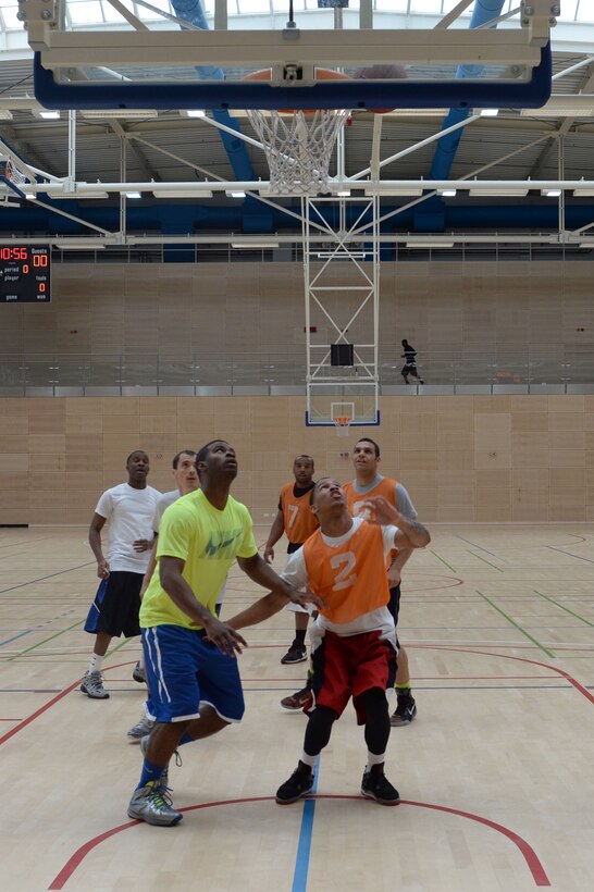 Team members from the 52nd Force Support Squadron and 606th Air Control Squadron wait for the ball to drop after a shot during a wing sports day basketball tournament at Spangdahlem Air Base, Germany, May 29, 2014. Airmen had the choice of playing basketball, kickball, dodge ball or golf and wing leadership participated in a tug of war at the end of the day. (U.S. Air Force photo by Senior Airman Alexis Siekert/Released)