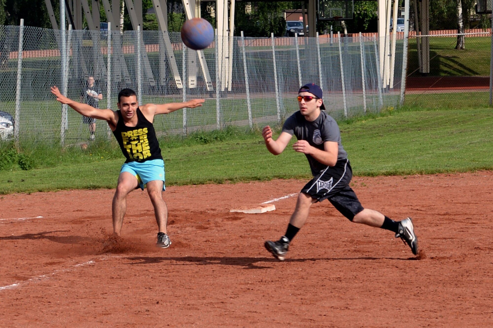 U.S. Air Force Senior Airman Gustavo Castillo, 52nd Fighter Wing Public Affairs photojournalist and Wing Staff Agency team member from Los Angeles, makes a hard stop off third base as a member of the 726th Air Mobility Squadron team makes a catch during a wing sports day kickball tournament at Spangdahlem Air Base, Germany, May 29, 2014. The WSA team won this match but was later eliminated in the tournament. (U.S. Air Force photo by Senior Airman Alexis Siekert/Released)