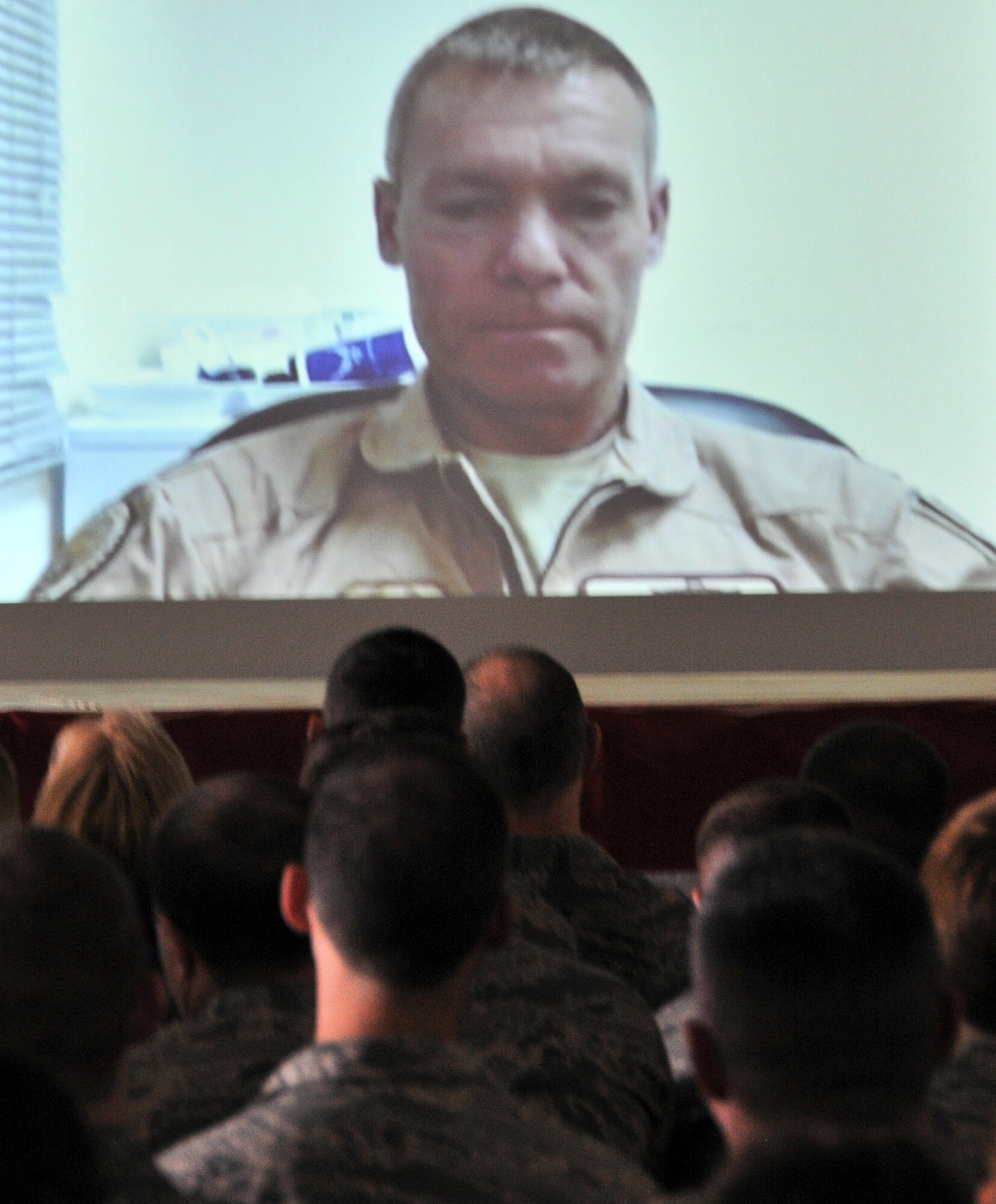 Col. Craig C. Peters, 911th Airlift Wing commander, surprises members of the 911 AW with a video conference call from his deployed location during a commander’s call at the Pittsburgh International Airport Air Reserve Stations’ May 2014 Unit Training Assembly. He addressed mission readiness and the Wingman Concept while stressing safety. (U.S. Air Force photo by Senior Airman Joshua J. Seybert)