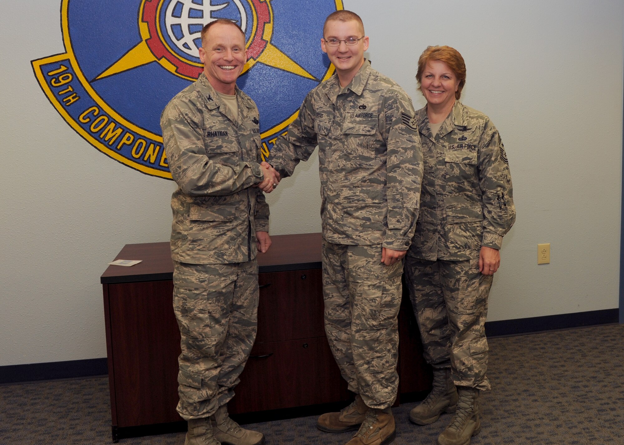 Col. Patrick Rhatigan, 19th Airlift Wing commander and Chief Master Sgt. Rhonda Buening, 19th AW command chief, congratulate Staff Sgt. Joseph Cross, a 19th Component Maintenance Squadron unit deployment manager May 27, 2014, at Little Rock Air Force Base, Ark. Cross a Jacksonville, N.C. native, exceeded the requirements of his duty during the ROCK EX by having all CMS personnel processed with zero mobility folder discrepancies. (U.S. Air Force photo by Airman 1st Class Scott Poe)  