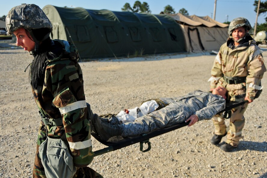 Capt. Leslie Newton, left, 4th Fighter Wing judge advocate general, and Staff Sgt. Christopher Bautista, 4th FW paralegal, carry a patient with simulated injuries, May 20, 2014, during Employment Exercise CORONET WARRIOR 14-02 at Seymour Johnson Air Force Base, North Carolina.  The exercise assessed Airmen’s readiness and ability to complete missions in a deployed environment.  (U.S. Air Force photo/Airman 1st Class Brittain Crolley)