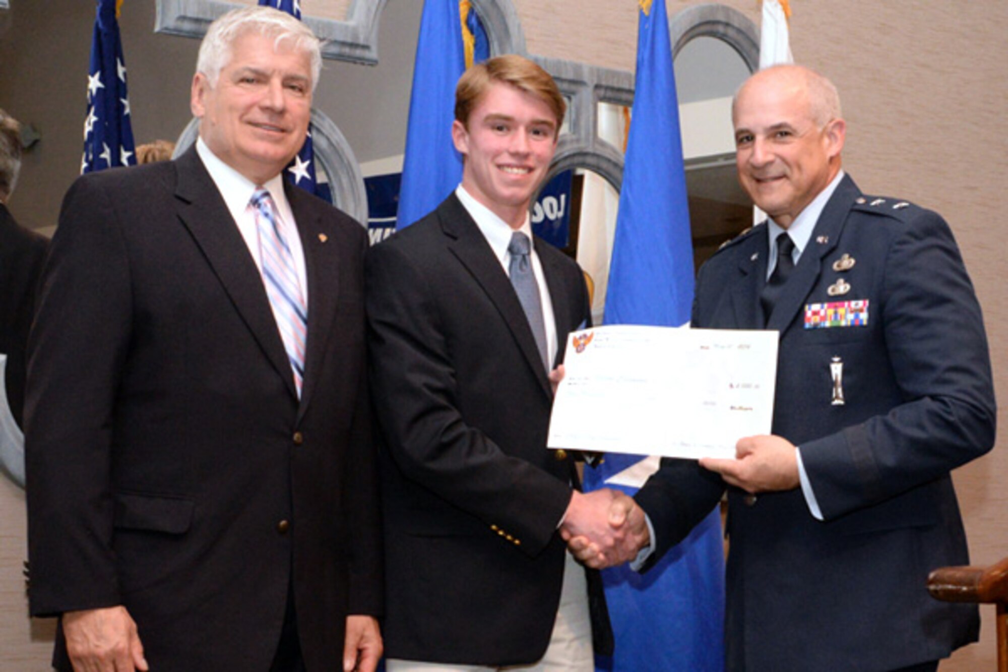 BOLTON, Mass. -- Maj Gen. Kenneth Merchant (right), director, Global Reach Programs, Office of the Assistant Secretary of the Air Force for Acquisition, and Paul Zauner (left), Air Force Association Paul Revere Chapter president, flank the Chief of Staff Scholarship winner, Jason Canavan, at the chapter’s annual scholarship dinner at the International here, May 21. Merchant was the keynote speaker and presented scholarships to three graduating high school seniors and two Airmen. Other scholarship recipients from the event include Alexander Knoedler, who was awarded the Colonel Chuck Jones Scholarship and Ellen Roussel, who was awarded the Mr. Brian Sweeney Scholarship. The Louis Emond scholarships were awarded to Tech. Sgt. Jaclyn Duclos and Senior Airman Francisco G. Trejo. (U.S. Air Force photo by Jennifer Green-Lanchoney)