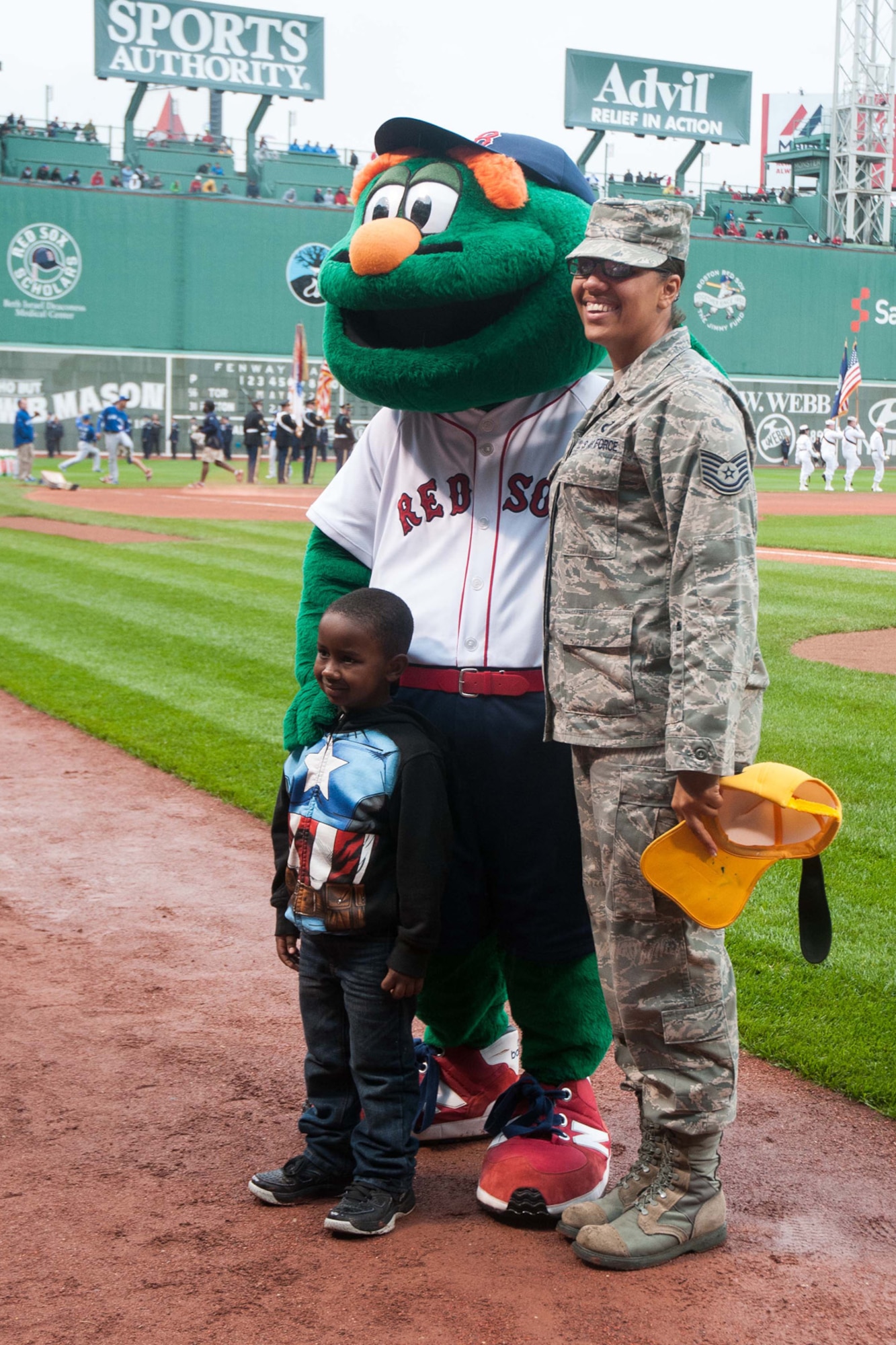 BOSTON – Tech Sgt. Chrystle Harvey, 66th Comptroller Squadron Accounting Liaison Office NCO in charge, and her 5-year old son Anthoney, pose with the Boston Red Sox mascot Wally the Green Monster on the field prior to the team playing the Toronto Blue Jays at Fenway Park, May 22. Harvey, who recently returned home from a deployment to Afghanistan, was recognized on the field alongside other servicemembers from the local area. More than 50 Airmen from Hanscom, as well as other servicemembers from the local area, attended the game for free as part of the 'Tickets for Troops' program, in which season ticket holders donated their game tickets to active-duty troops. (U.S. Air Force photo by Mark Herlihy)