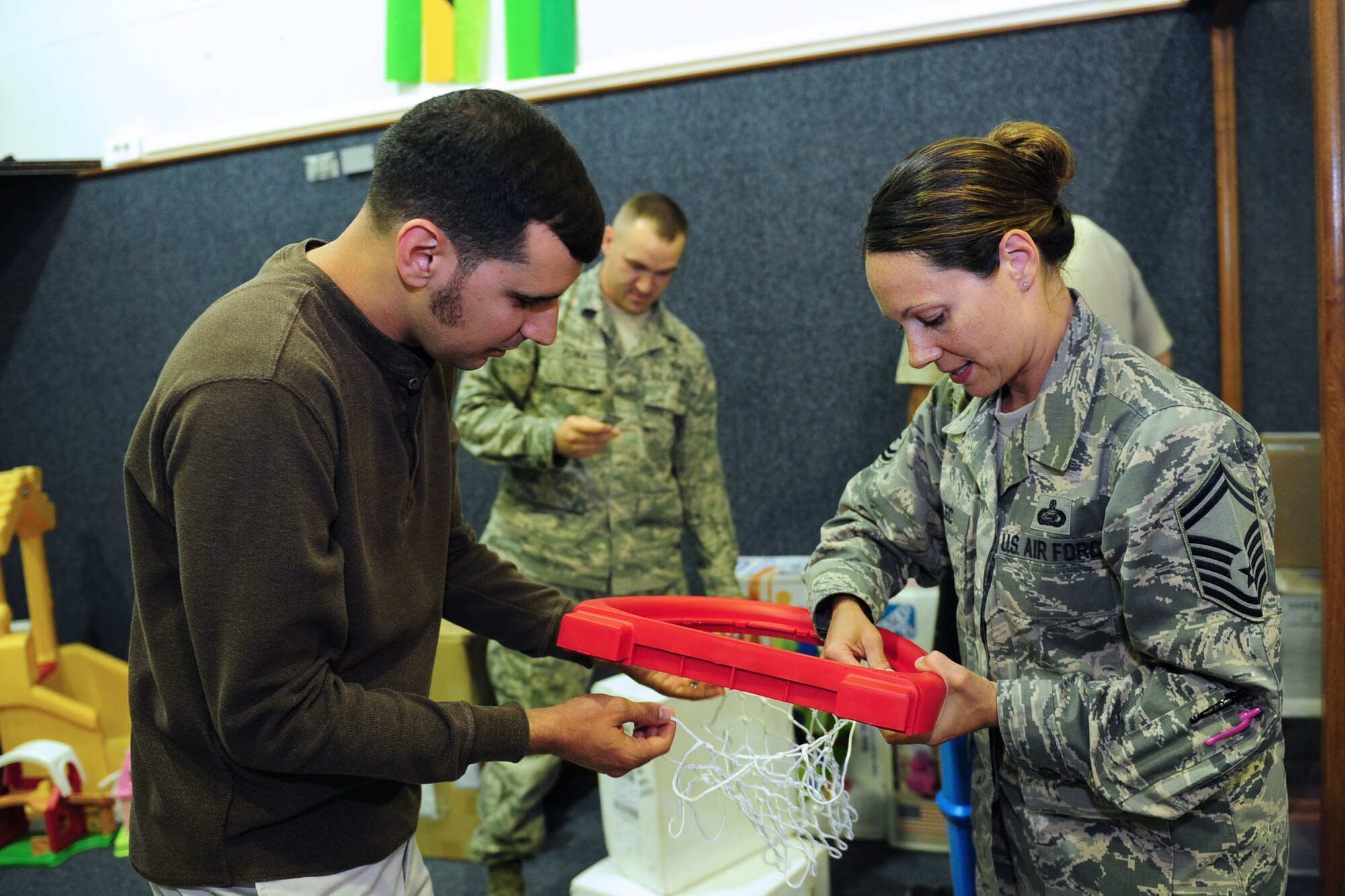 Joe Dyson, 39th Force Support Squadron sustainment services flight chief, and Senior Master Sgt. Trisha Malec, 39th FSS superintendent, assemble a basketball net May 14, 2014, Incirlik Air Base, Turkey.  The Incirlik Air Base First Sergeants council came together to modernize and improve the children’s play area at the 39th FSS Fitness Center. (U.S. Air Force photo by Senior Airman Nicole Sikorski/Released) 

