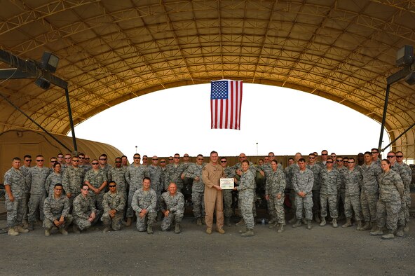 Col. James Copher, 380th Air Expeditionary Wing vice commander, presents Senior Airman Kasey Clive, 380th Expeditionary Maintenance Squadron, a warrior of the week certificate at an undisclosed location in Southwest Asia, May 28, 2014. Clive, a native of Indianapolis, Ind., is deployed from Royal Air Force Lakenheath, England. (U.S. Air Force photo by Tech. Sgt. Russ Scalf/Released)