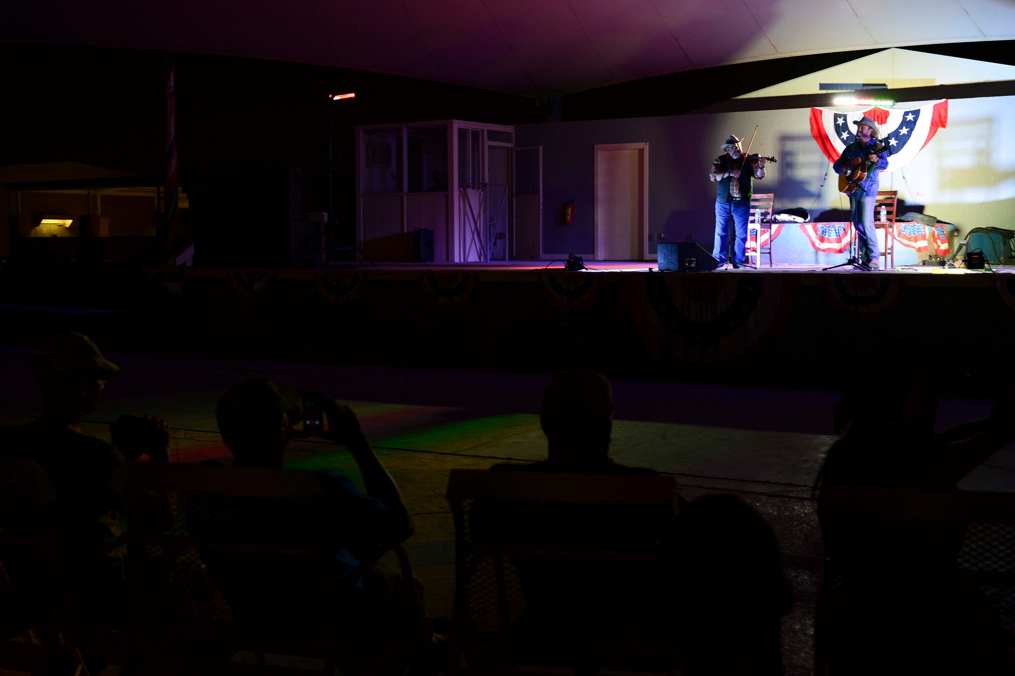Service members watch as country singer, Charlie Zahm, performs at Al Udeid Air Base, Qatar, May 26, 2014. Zahm performed as part of activities at AUAB in recognition of Memorial Day. (U.S. Air Force photo by Staff Sgt. Ciara Wymbs)