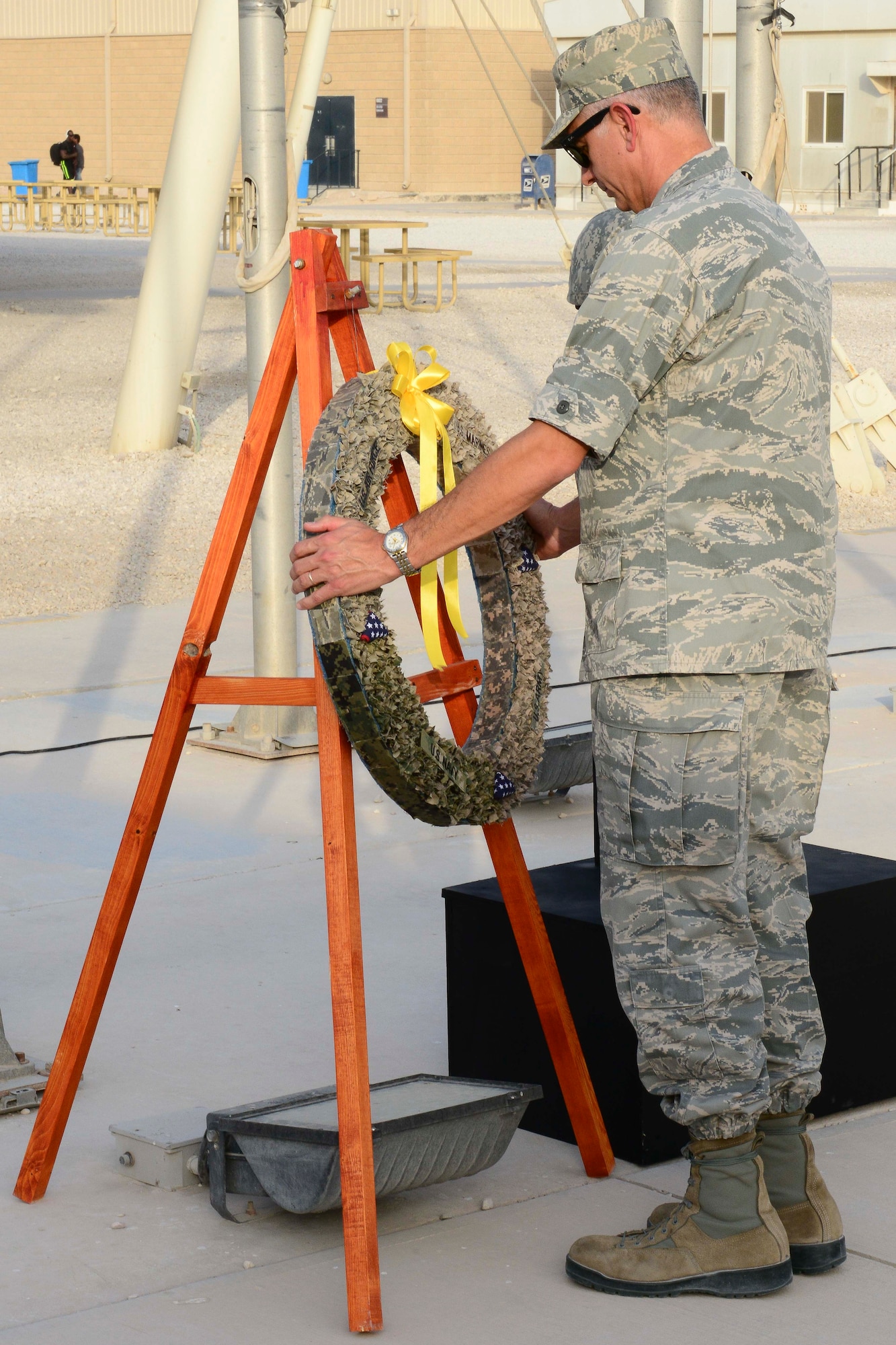 U.S. Air Force Brig. Gen. Roger H. Watkins places a wreath during a Memorial Day retreat ceremony at Al Udeid Air Base, Qatar, May 26, 2014. The ceremony recognized Service members that paid the ultimate sacrifice for our country. (U.S. Air Force photo by Staff Sgt. Ciara Wymbs)