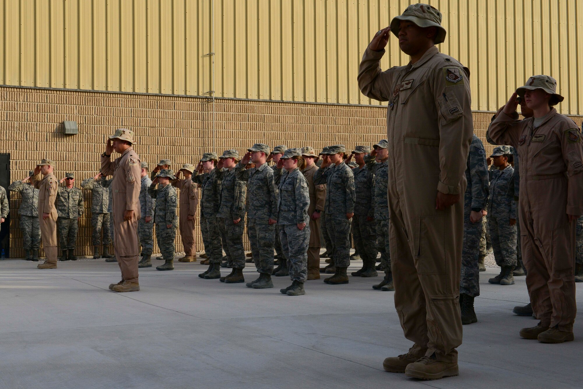 U.S. Air Force Airmen assigned to the 379th Expeditionary Operations Group salute as Taps is played at Al Udeid Air Base, Qatar, May 26, 2014. The group was part of a retreat ceremony for Memorial Day, saluting the Service members that paid the ultimate sacrifice for our country. (U.S. Air Force photo by Staff Sgt. Ciara Wymbs)