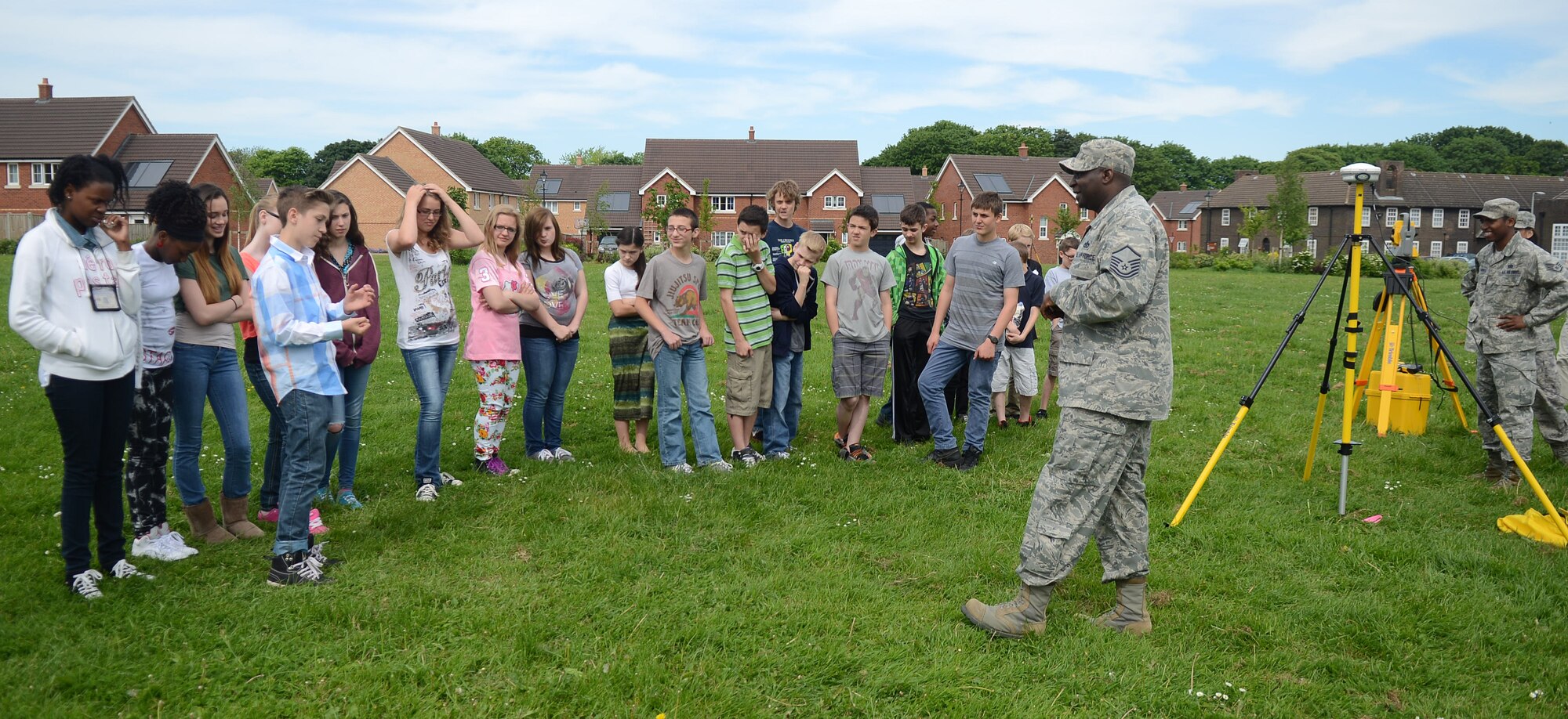 U.S. Air Force Master Sgt. Solomon Vincent, right, 100th Civil Engineer Squadron engineering flight superintendent from Bladensburg, Md., teaches Lakenheath Middle School children about conventional and GPS surveying methods during a Geographic Information System Day May 21, 2014, on RAF Feltwell, England. The day gave the children an opportunity to see how math and geography can help them measure points on the earth and can be used to make maps, navigation and beddown planning in a contingency environment. (U.S. Air Force photo by Airman 1st Class Kyla Gifford/Released)