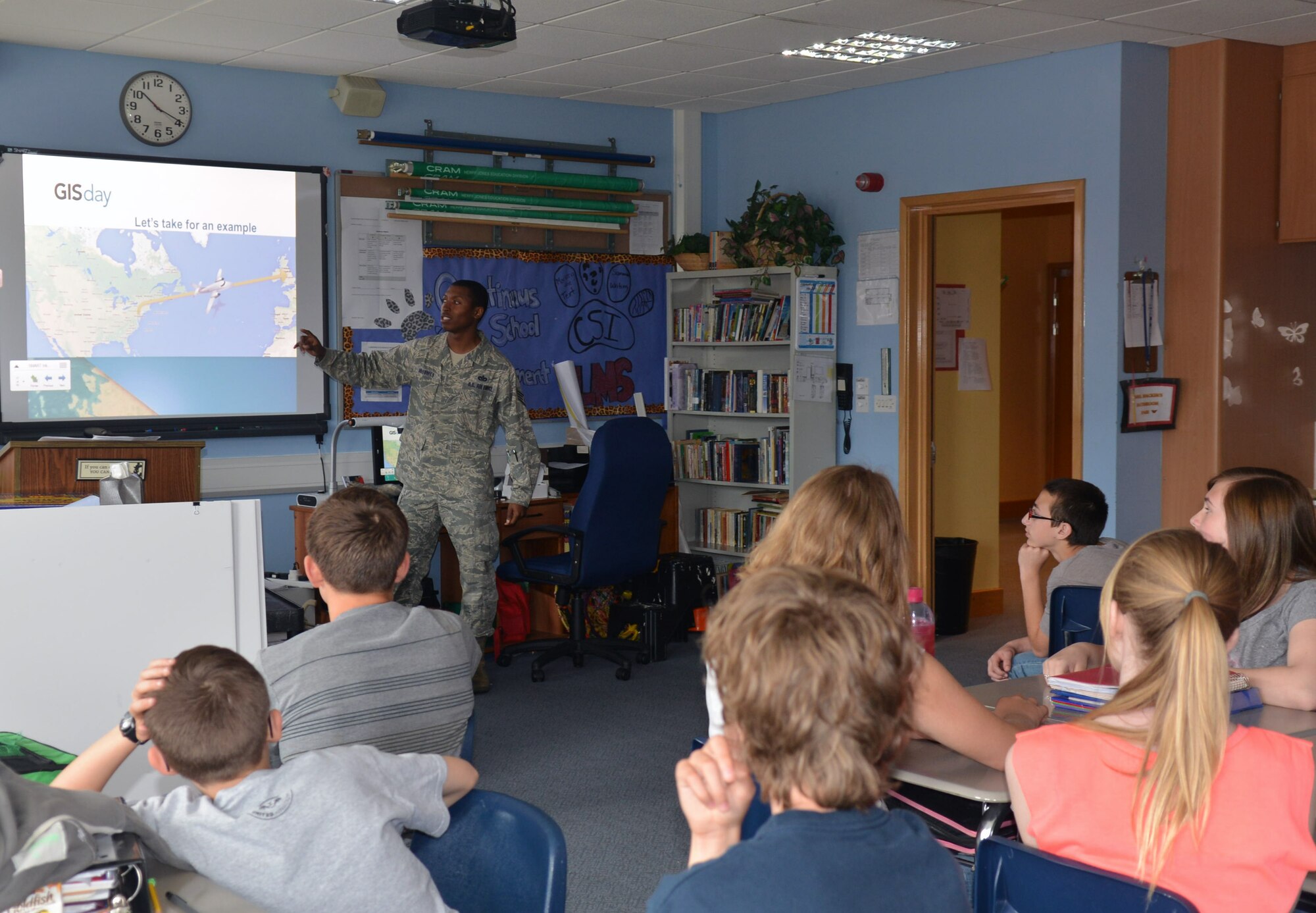 U.S. Air Force Staff Sgt. Erik Holloman, 100th Civil Engineer Squadron NCO in charge of geobase from Washington, D.C., teaches Lakenheath Middle School children about conventional and GPS surveying methods during a Geographic Information System Day May 21, 2014, on RAF Feltwell, England. The day gave children an opportunity to see how math and geography can help them measure points on the earth and can be used to make maps, navigation and beddown planning in a contingency environment. (U.S. Air Force photo by Airman 1st Class Kyla Gifford/Released) 