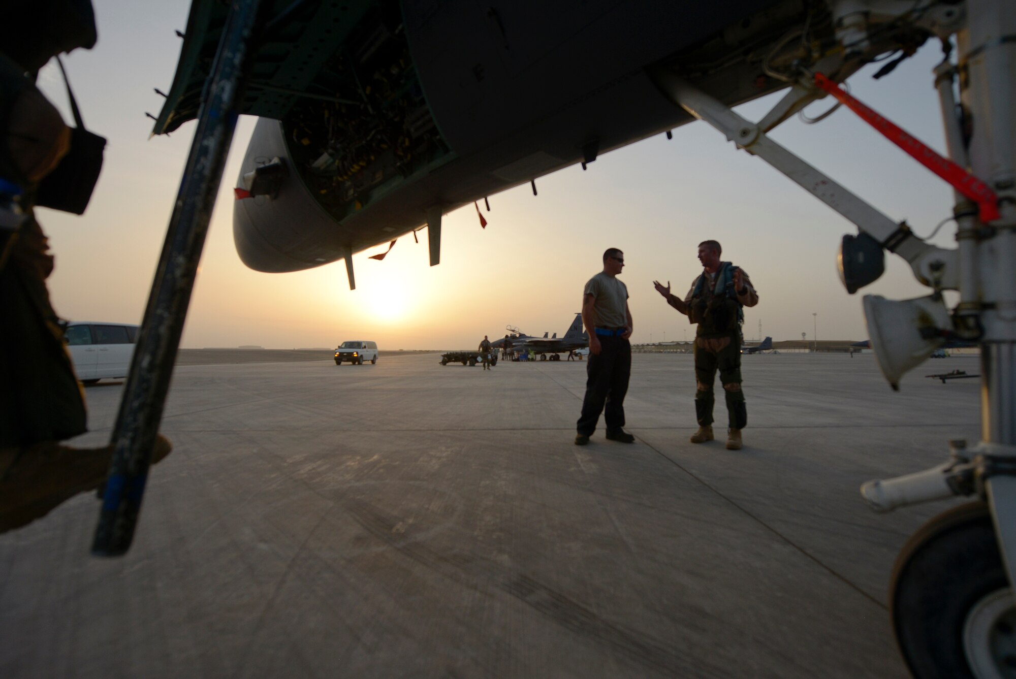 Staff Sgt. Andrew McNeal, a 380th Expeditionary Aircraft Maintenance Squadron crew chief, speaks with an F-15E Strike Eagle aircrew member after a flight May 26, 2014, at an undisclosed location in Southwest Asia. Aircrew members provide feedback to crew chiefs about the performance of the aircraft during the flight, which may help determine any necessary maintenance requirements.  (U.S. Air Force photo byTech. Sgt. Russ Scalf/Released)